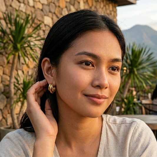 Lifestyle image of a woman wearing Vibe Atelier GleamSet 4-Piece Gold Claw Stud Earrings, side angle.