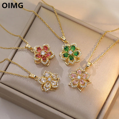 Four OIMG gold-plated rotatable flower necklaces with zirconia centerpieces in red, green, clear, and pink.