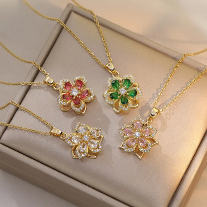 Four gold-plated rotatable flower necklaces with zirconia centerpieces in red, green, clear, and pink.