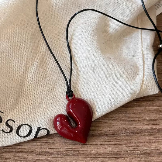 Vibe Atelier Crimson Love Vintage Heart Necklace, a red heart pendant on a black choker-length chain, front view.