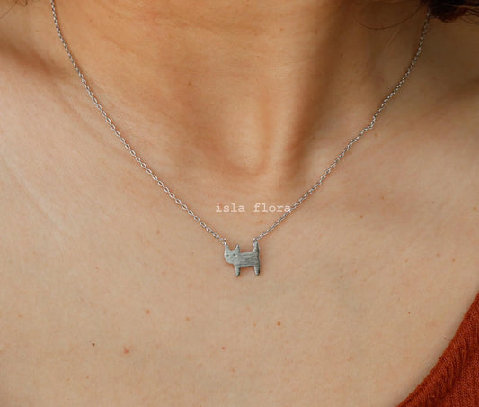 Vibe Atelier Whiskered Whisper Cat Necklace in silver, featuring a minimalist cat pendant with a brushed finish, worn on a model's neck.